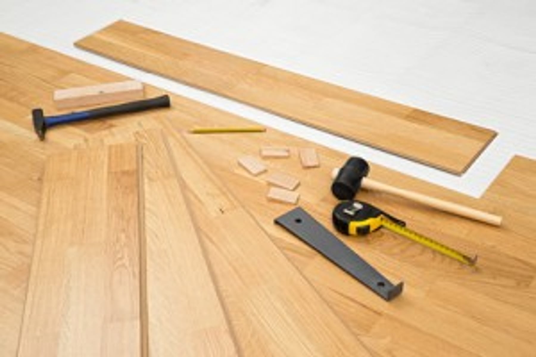 Bodenverlegung mit Werkzeug und Holzdielen